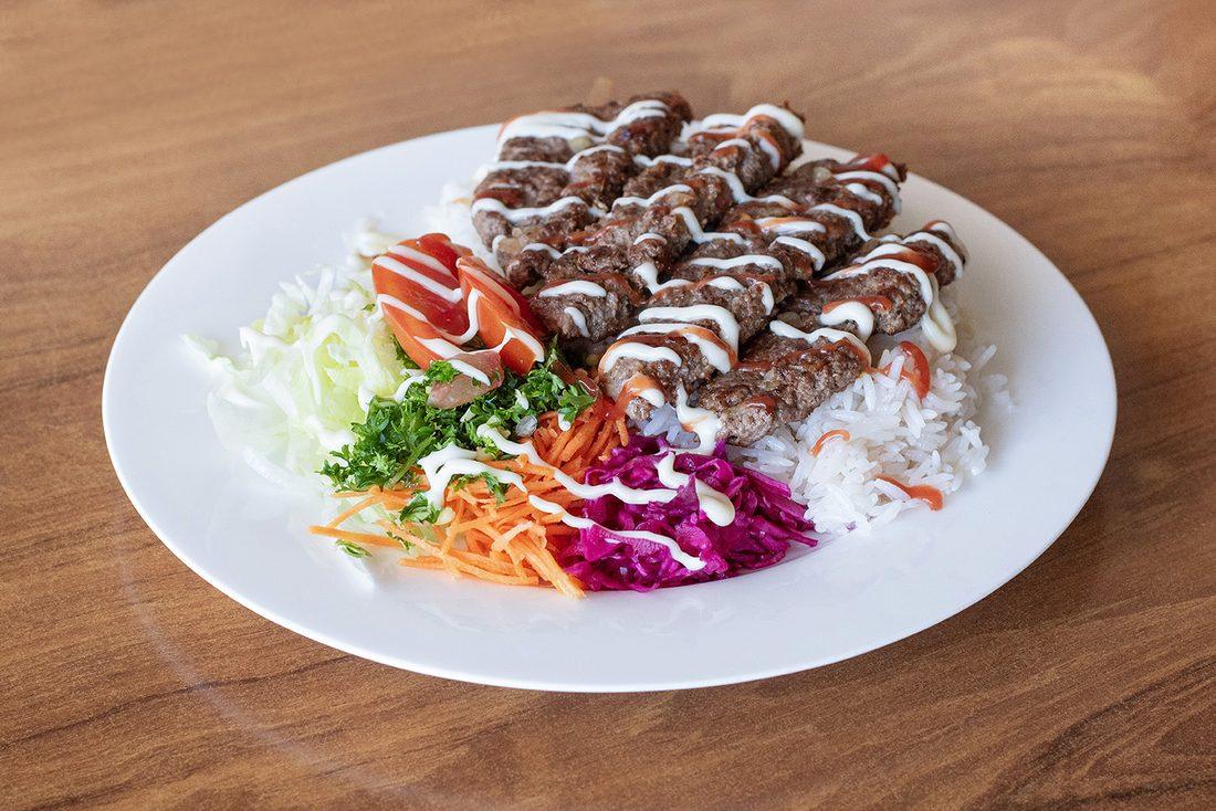 Beef kofte skewers on rice with salad